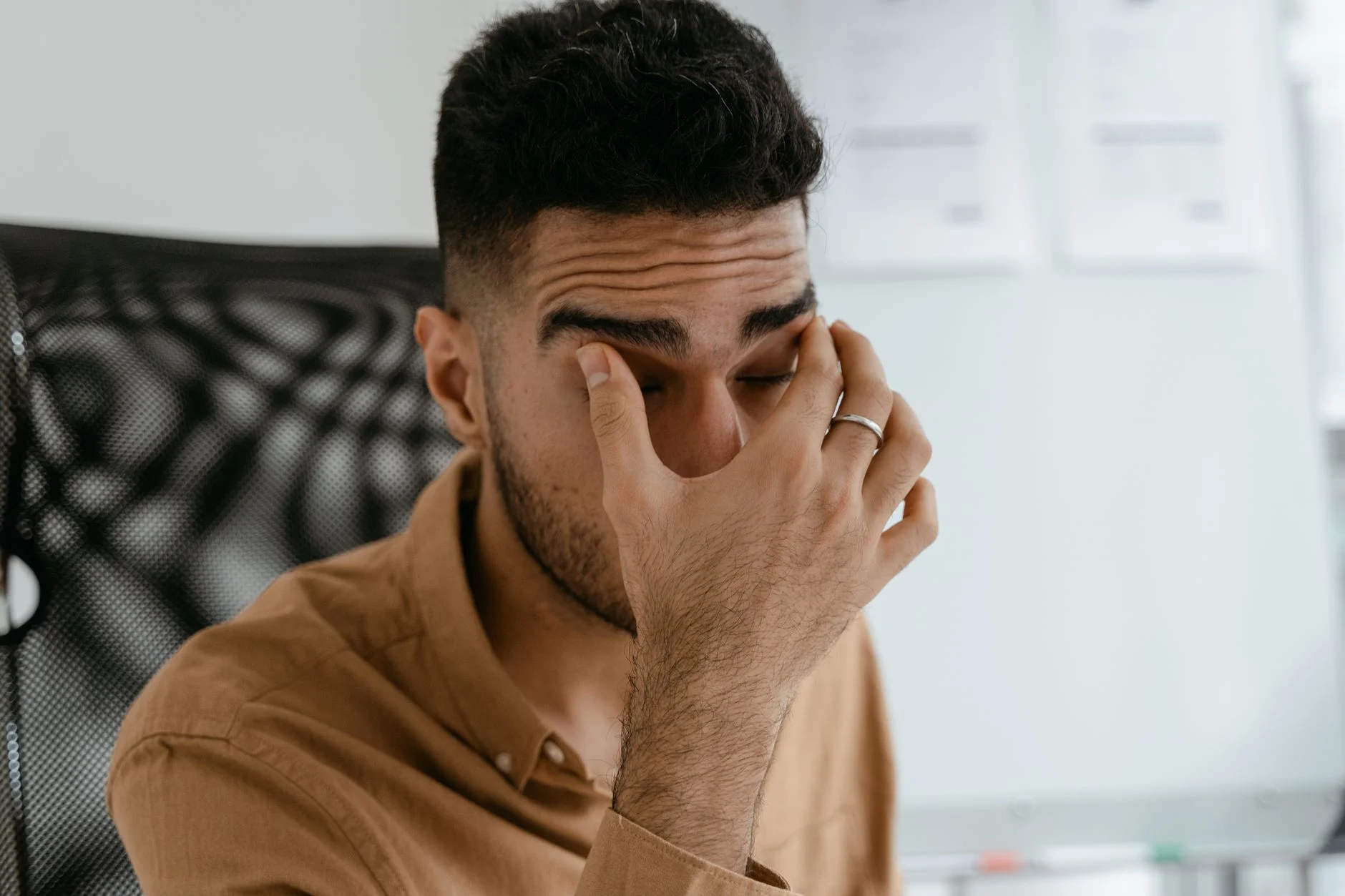 Pessoa esfregando os olhos cansados após uso de celular por causa do pwm na tela do celular